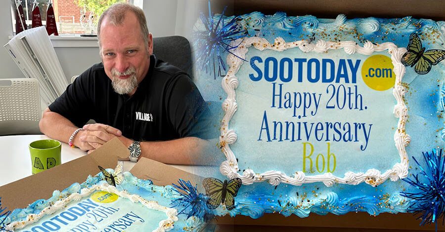 Rob Speers posing with a cake that reads "SooToday.com Happy 25th Anniversary Rob"