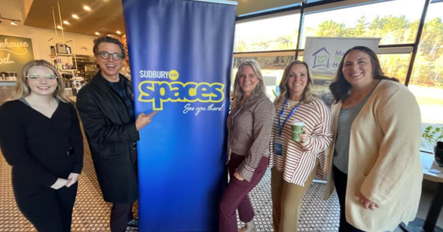 Allison Hall (left), Mark Gentili, Melanie Junge, Jennifer Mallette and Sarah Braumberger pose in front of the SPACES banner at Good Earth Coffeehouse