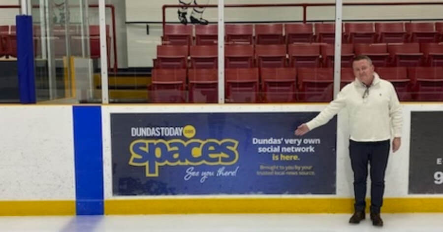 Daniel Coleman pointing at a Dundas Spaces advertisement.