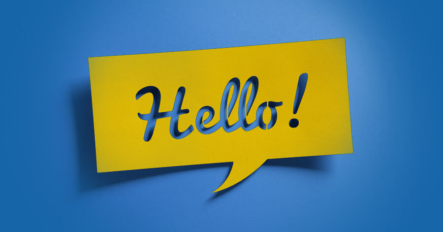 "Hello!" text written in a script font, cut out from a piece of paper shaped like a speech bubble.